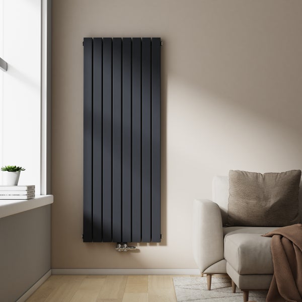 Vertikaler Paneelheizkörper im Wohnzimmer neben einem Sofa.