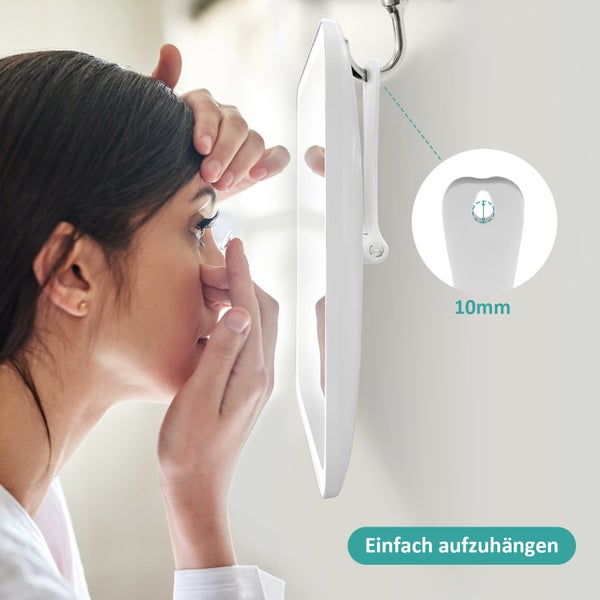 Frau setzt Kontaktlinse vor einem Kosmetikspiegel ein, der an einem Haken hängt