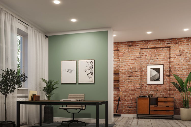 Büro mit Schreibtisch, Stuhl, Pflanzen und Wanddekoration in einem hellen Raum