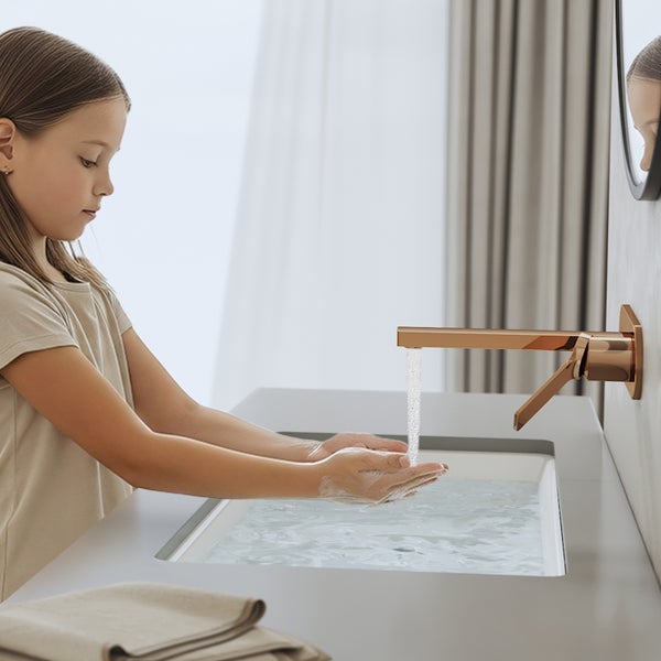 Mädchen wäscht sich die Hände an einem Waschbecken mit Armatur.