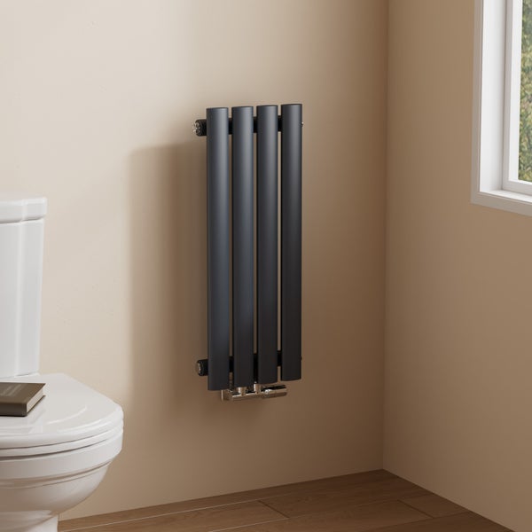 Schwarzer Heizkörper im Badezimmer neben Toilette und Fenster