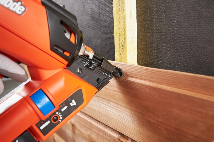 Nagelpistole beim Befestigen von Holzpaneelen an einer Wand