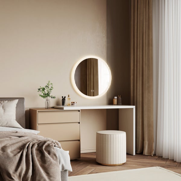 Ein moderner Schminktisch mit rundem LED Spiegel und gepolstertem Hocker in einem eleganten Schlafzimmer mit Parkettboden und Vorhängen.