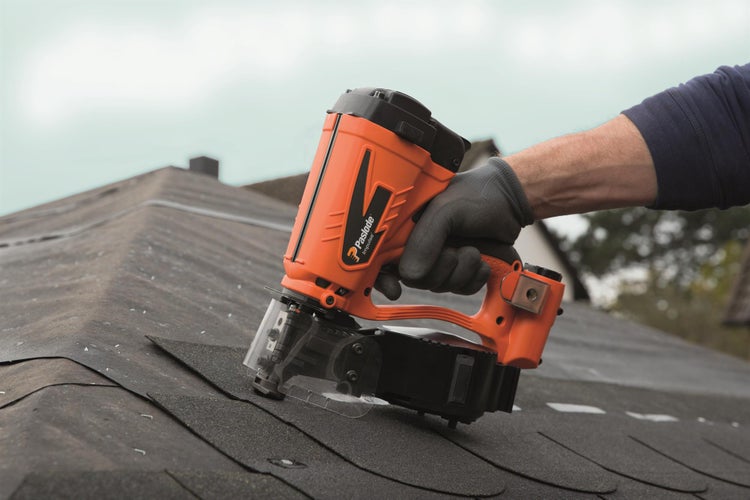 Eine Person benutzt einen Paslode Impuls Dachpappnagler auf einem Dach