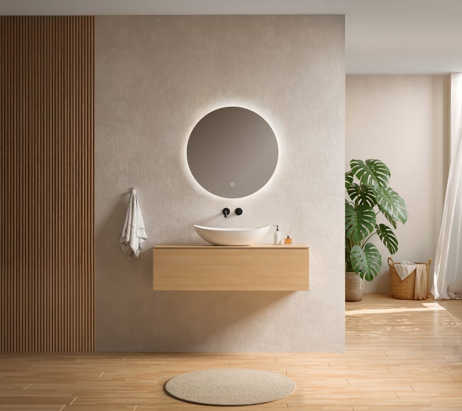 Modernes, helles Badezimmer mit schwebendem Waschtisch aus Holz, weißem Aufsatzwaschbecken und rundem LED-Spiegel an einer strukturierten Wand.