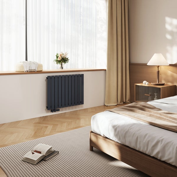 Schlafzimmer mit Heizkörper, Bett und Fenster
