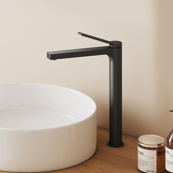 Schwarze matte Waschtischarmatur mit hohem Auslauf an einem weißen Aufsatzwaschbecken auf einer Holzplatte.