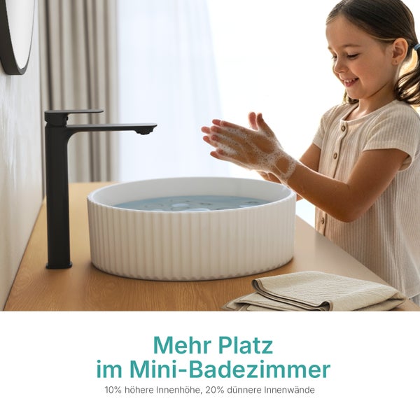 Mädchen wäscht sich die Hände in einem weißen Aufsatzwaschbecken mit einer schwarzen Armatur in einem Badezimmer.