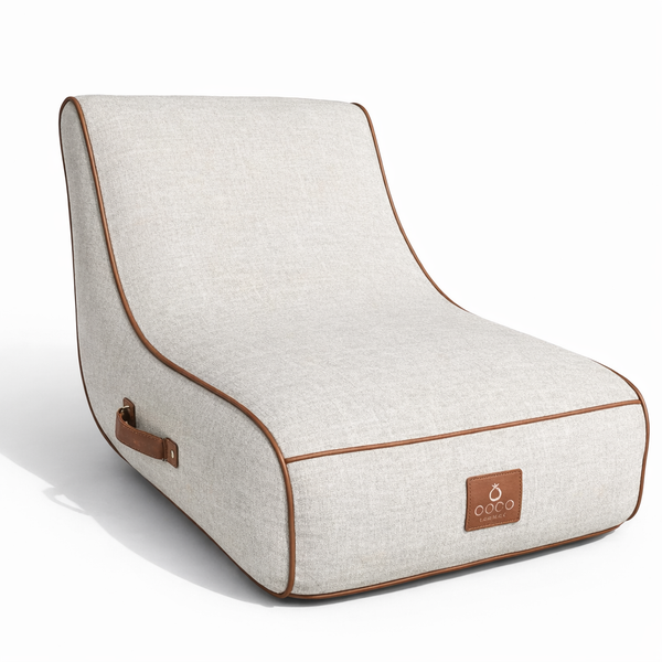 Ergonomischer Sitzsack Lounger mit hellem Textilbezug, brauner Paspelierung und praktischem Tragegriff aus Lederimitat.