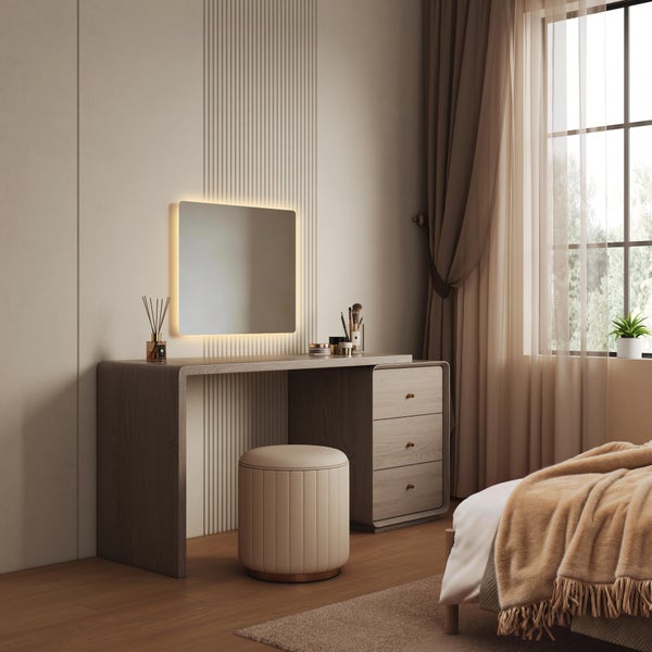 Moderner Schminktisch aus Holz mit beleuchtetem Wandspiegel und passendem Sitzhocker in einem hellen, gemütlich eingerichteten Schlafzimmer.