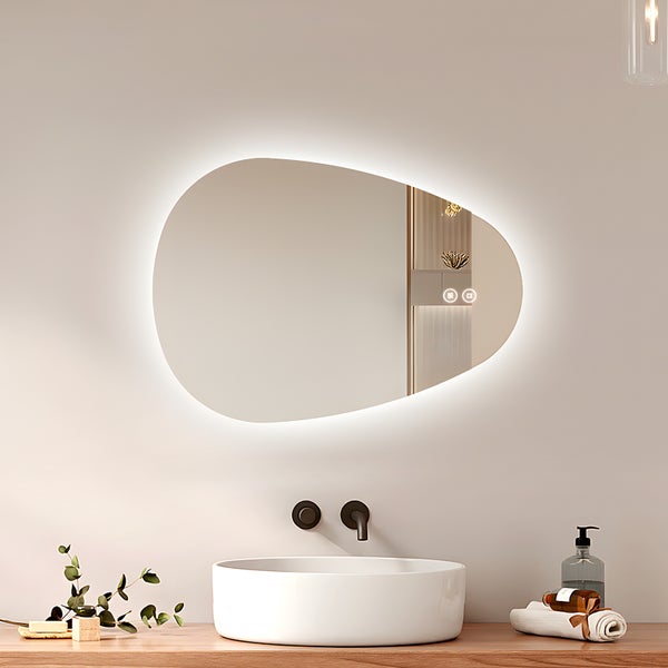 Organisch geformter Badezimmerspiegel mit umlaufender LED Beleuchtung und Touch Steuerung über einem Waschbecken auf einer Holzplatte.
