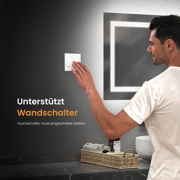 Ein Mann bedient einen Wandschalter in einem Badezimmer mit beleuchtetem Spiegel