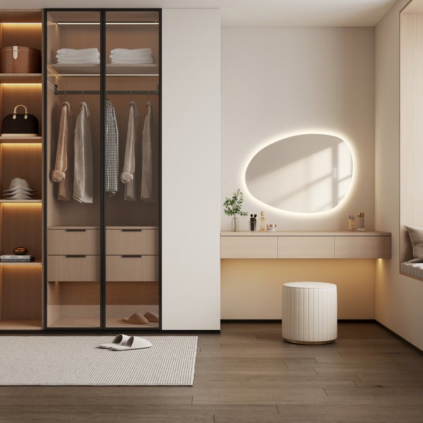 Modernes Ankleidezimmer mit integriertem Schminktisch, beleuchtetem organischem Spiegel, Kleiderschrank mit Glastüren und indirekter Beleuchtung.