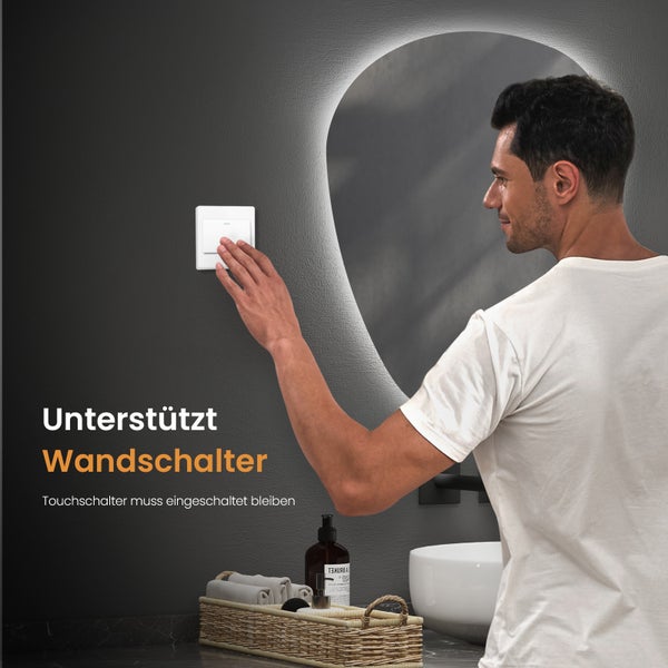 Mann bedient einen Lichtschalter im Badezimmer mit Spiegel und Waschbecken