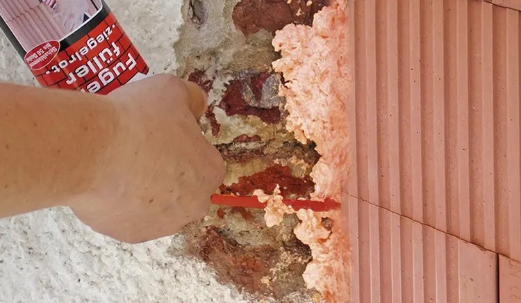 Auftragen von Fugenfüller Ziegelrot auf Mauerwerk