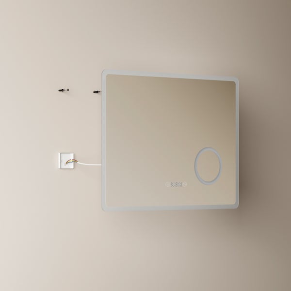 Rechteckiger Badezimmerspiegel mit LED Beleuchtung, integrierter Digitaluhr und kosmetischem Vergrößerungsbereich vor einer Wandmontage