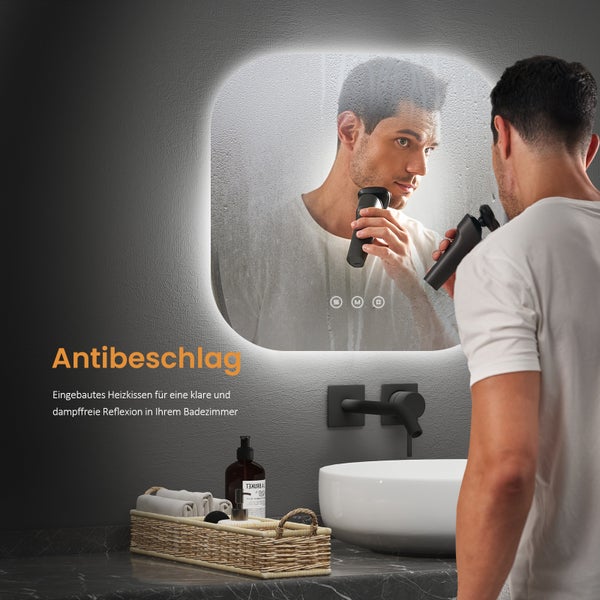 Badezimmerszene mit einem Mann, der sich vor einem beschlagfreien Spiegel rasiert, mit Waschtisch und Accessoires