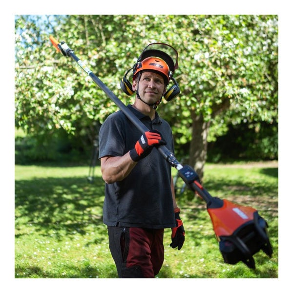 Mann mit Helm und Hochentaster im Garten