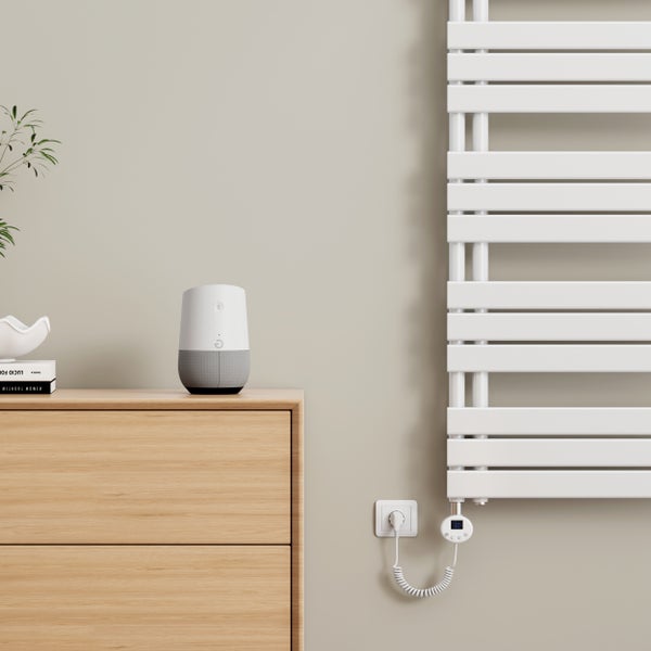 Szene mit einem elektronischen Handtuchwärmer, an der Wand montiert, neben einem Nachttisch mit Smart Speaker
