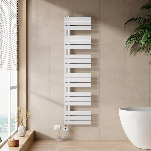 Moderner weißer Elektro-Badheizkörper mit Digitalthermostat an einer beigen Fliesenwand in einem hellen Badezimmer mit Badewanne.