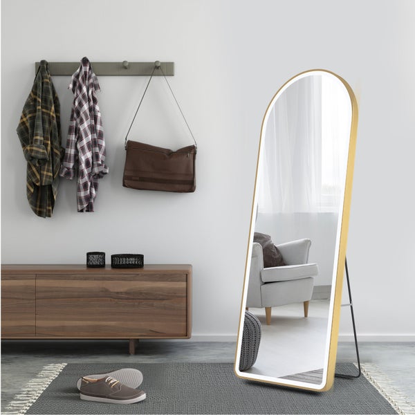 Moderner Ganzkörperspiegel in Bogenform mit LED-Beleuchtung und Goldrahmen in einem hellen Flur mit Sideboard und Teppich.