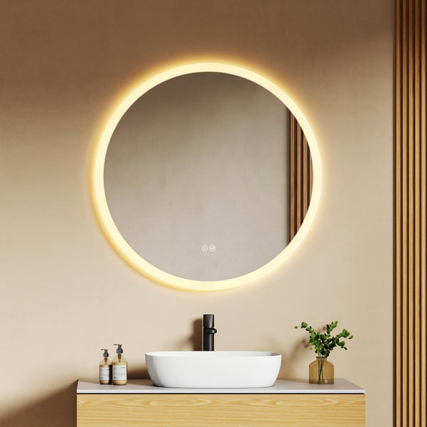 Runder Badezimmerspiegel mit LED-Beleuchtung über einem weißen Aufsatzwaschbecken und Waschtisch in Holzoptik.