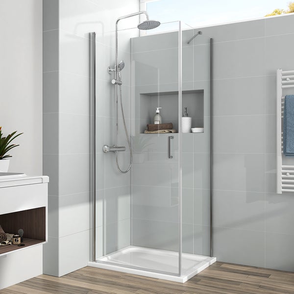 Eckdusche aus Glas mit Drehtür, verchromte Armaturen, Regendusche und Handbrause in einem hellen Badezimmer mit grauen Fliesen.