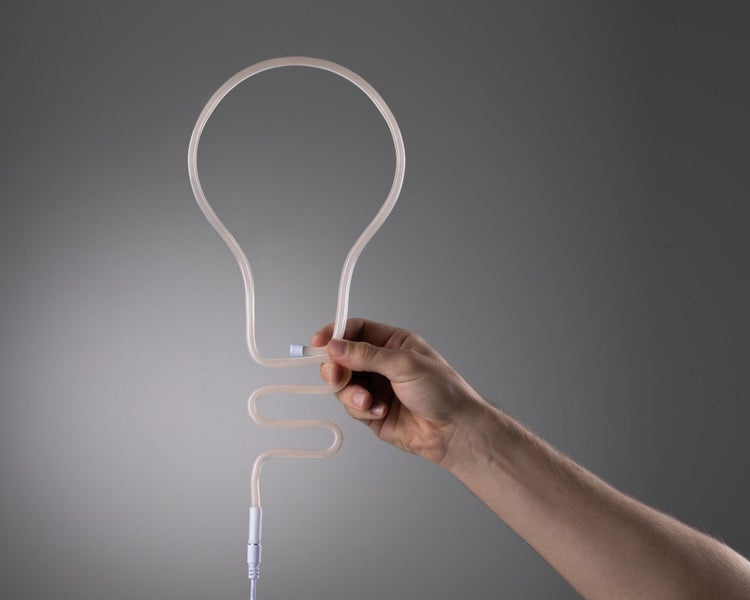 Hand hält eine Lampe aus einer flexiblen Röhre