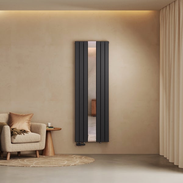 Vertikaler Design-Heizkörper in Anthrazit mit integriertem Ganzkörperspiegel in einem modernen Wohnzimmer mit Sessel und Vorhängen.