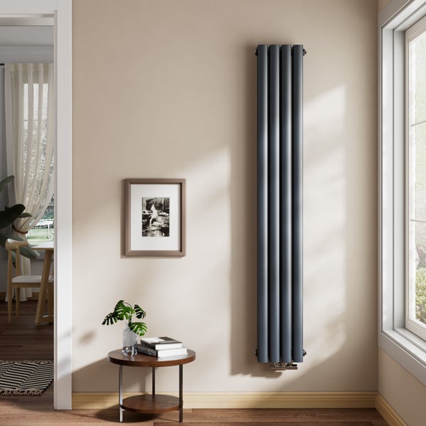 Vertikaler Design-Heizkörper aus Stahl in einem hellen, modern eingerichteten Wohnraum neben einem Fenster montiert.