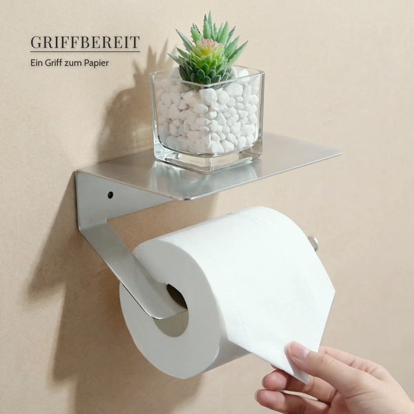 Wandmontierter Toilettenpapierhalter aus Metall mit integrierter Ablage für Badezimmerzubehör.