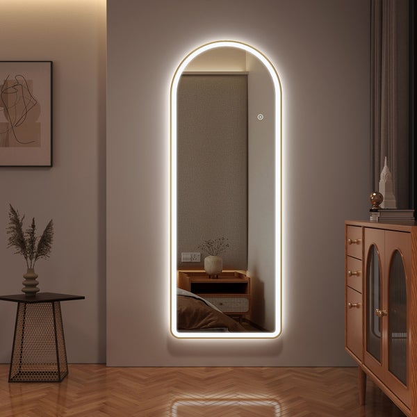 Beleuchteter, rahmenloser Ganzkörperspiegel mit abgerundeter Oberseite in einem Schlafzimmer