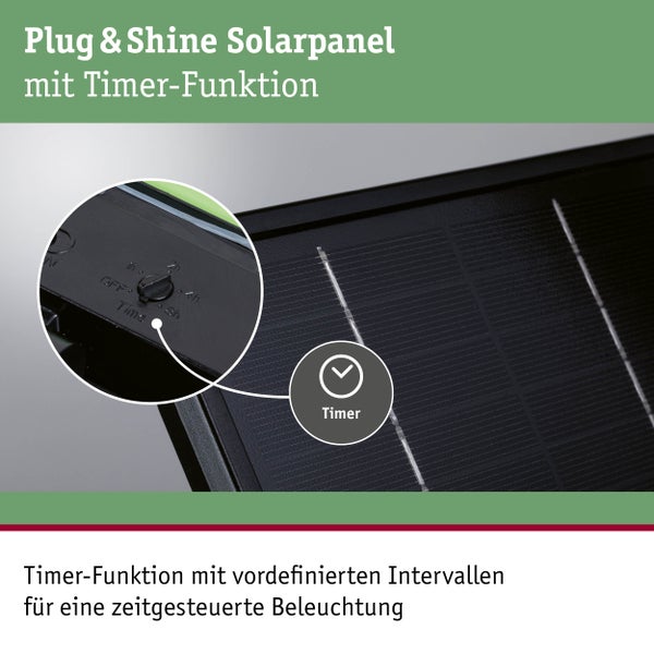 Solar-Gartenstrahler mit Solarpanel beleuchtet Busch in modernem Garten bei Nacht. Steinweg und Terrasse mit Loungemöbeln sind sichtbar.