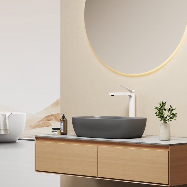 Modernes Badezimmer mit Waschtisch aus Holz, Aufsatzwaschbecken, Waschtischarmatur, beleuchtetem Spiegel und freistehender Badewanne.