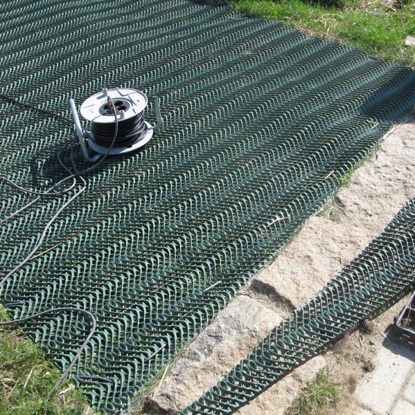 Kunststoff Rasengitter auf dem Boden ausgelegt mit einer Kabeltrommel im Garten