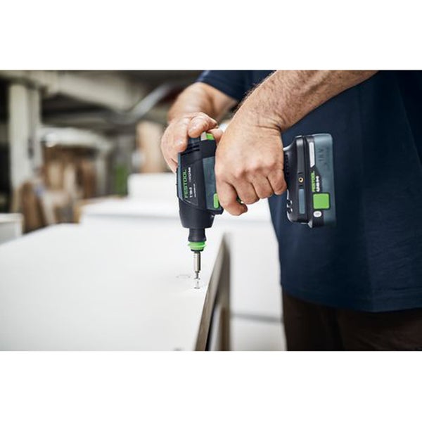 Ein Handwerker nutzt einen akkubetriebenen Festool Akkuschrauber zum Verschrauben einer Holzplatte in einer Werkstatt.