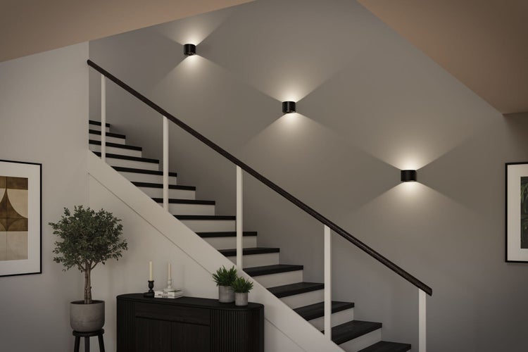 Treppenhaus mit drei zylindrischen Wandleuchten, Treppe und Dekoration