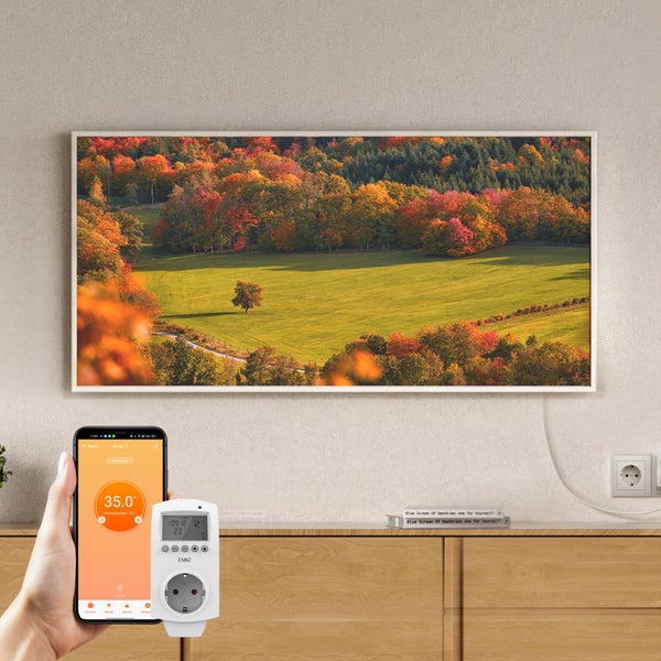 Infrarotheizung mit Landschaftsmotiv an der Wand montiert, gesteuert durch ein Smartphone und einen steckbaren Thermostatregler.