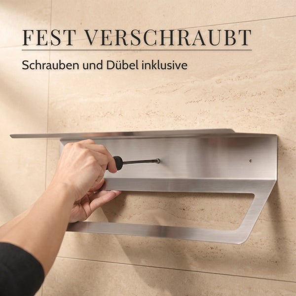 Eine Hand schraubt eine Wandablage aus Metall mit integriertem Handtuchhalter an eine geflieste Wand.