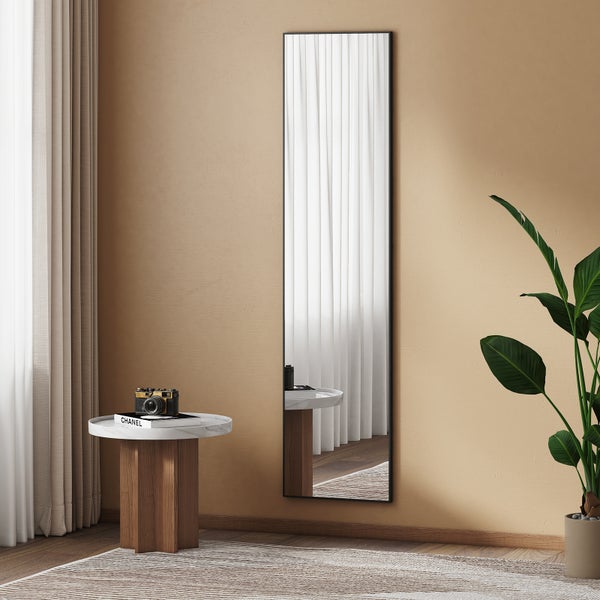 Einrichtungsszene mit einem schlanken Spiegel, einem Beistelltisch und Zimmerpflanzen