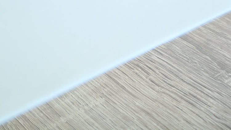 Detailansicht einer glatten Oberfläche und einer Oberfläche mit Holzstruktur.