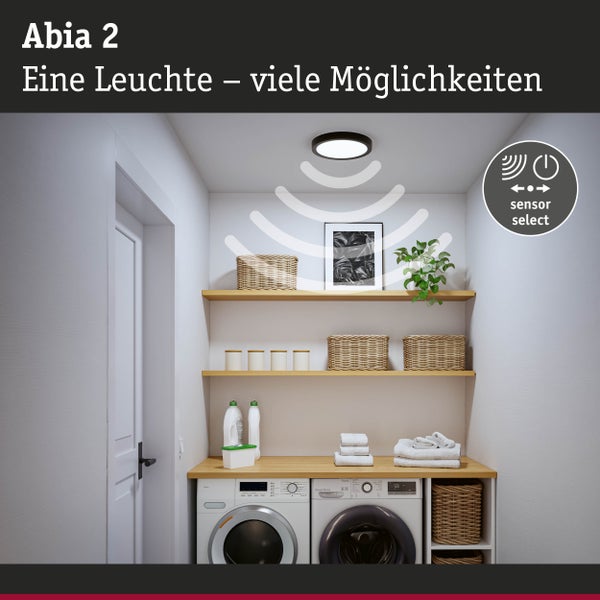 Wäschezimmer mit Deckenleuchte, Regalen, Waschmaschine und Wäschetrockner