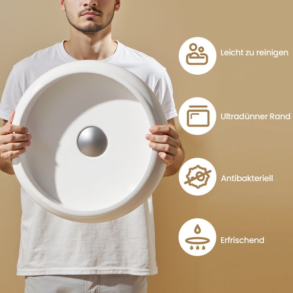 Mann hält Aufsatzwaschbecken mit Merkmalen für einfache Reinigung, ultradünnen Rand und antibakterielle Wirkung.