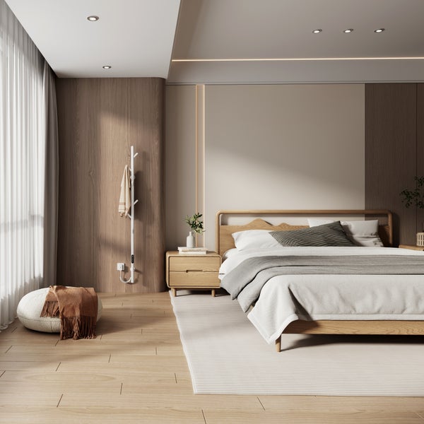 Schlafzimmer mit Holzboden, Bett, Nachttisch und Heizkörper