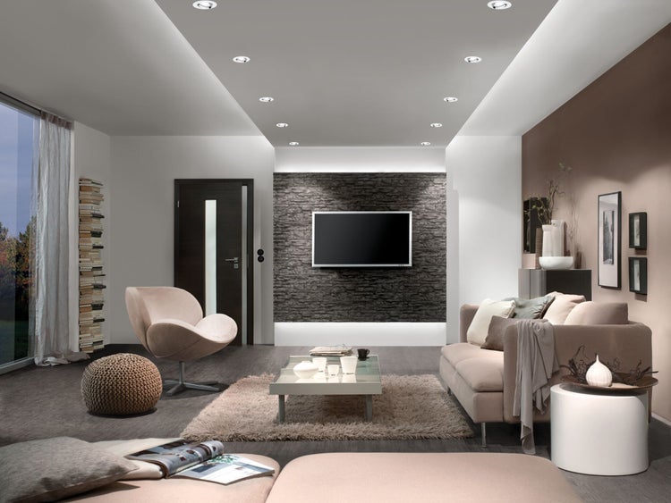 Wohnzimmer mit Sofa, Sessel, Couchtisch und Deckenleuchten