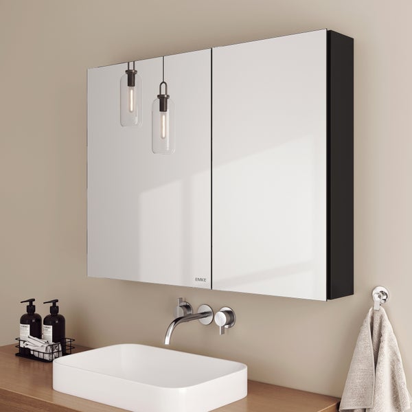 Moderner Spiegelschrank mit zwei Spiegeltüren über einem Waschbecken mit Armatur und Zubehör in einem Badezimmer.