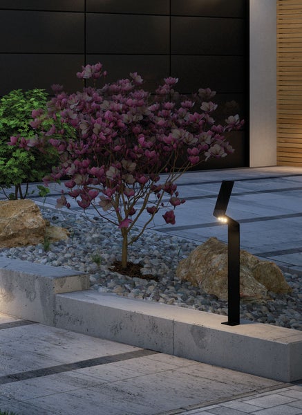 Szene mit einem modernen Gartenweg mit Wegleuchte, Steinen und Bepflanzung