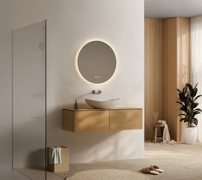 Modernes Badezimmer mit hängendem Holz-Waschtischunterschrank, weißem Aufsatzwaschbecken und rundem LED-Spiegel vor heller Wand.
