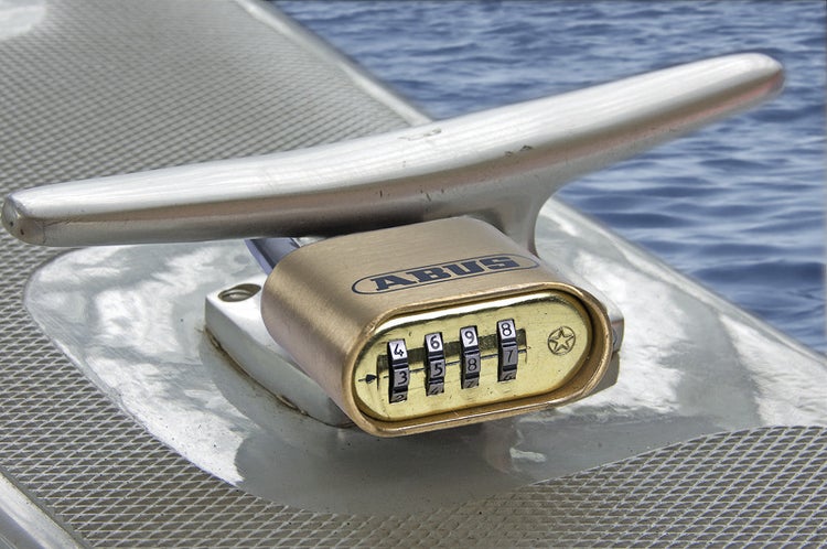 ABUS Messing-Zahlenschloss an einer Bootsklampe befestigt.