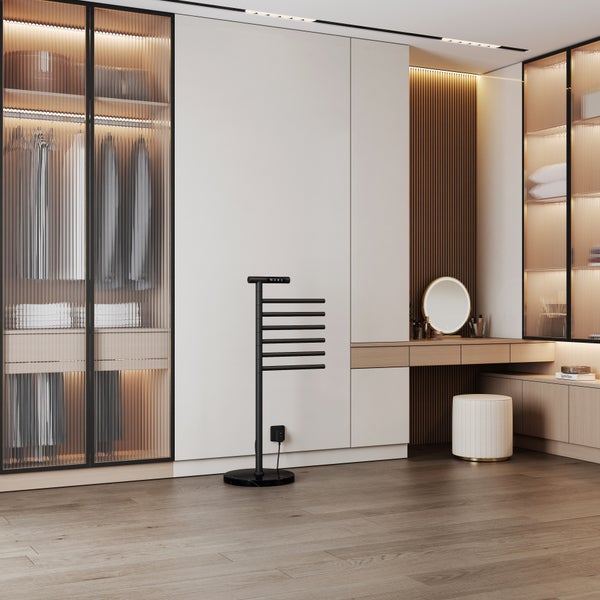Freistehender elektrischer Handtuchwärmer in modernem Ankleidezimmer mit Kleiderschränken und Schminktisch.